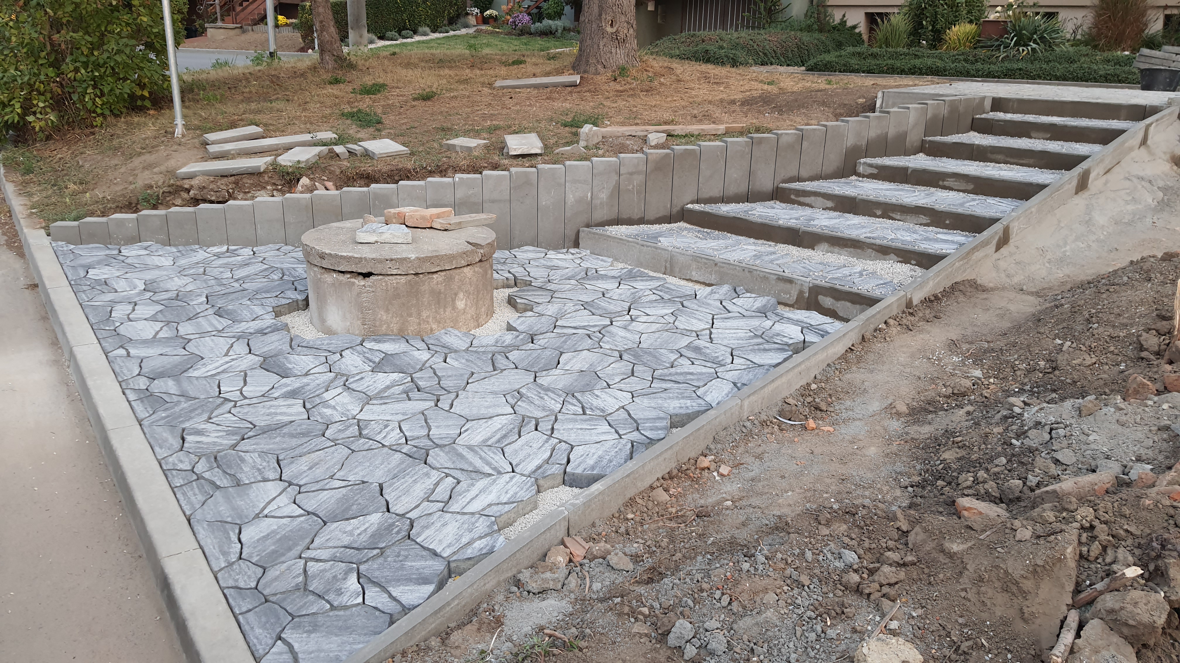 Dlážděná plocha kolem studny a schodiště